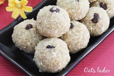 a black plate filled with cookies and raisins on top of a red tablecloth