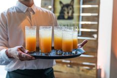 a man holding a tray with drinks on it