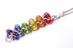 This unusual and modern pendant necklace is made of stainless steel rings and rainbow coloured miyuki beads. The sterling silver S clasp can be connected at either end of the beaded section allowing two unusual and versatile looks. This version features a Pride rainbow, and can also be made in a seven colour rainbow (slightly longer), perfect to show your Pride, or if you just like rainbows. Your handmade necklace is: * Made to order. * Made ring-by-ring with care by myself in York, England - I open and close each link myself. * Made of stainless steel rings and genuine Miyuki beads on a stainless steel chain with a sterling silver S clasp. * 49cm long at minimum, but can be made to a different length if requested via a custom order. * The pendant length varies dependent on the colours use Miyuki Bead, York England, Rainbow Necklace, Hard Metal, Pride Rainbow, Bead Pendant, Miyuki Beads, Chain Mail, Rainbow Pride