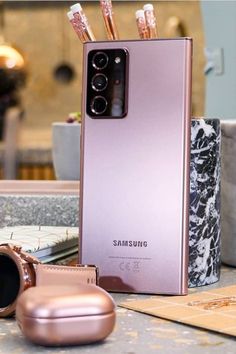 a pink samsung phone sitting on top of a table