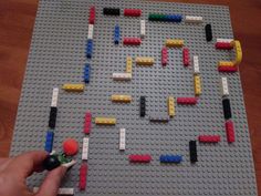 a person is playing with legos on the table, and they are making something out of them