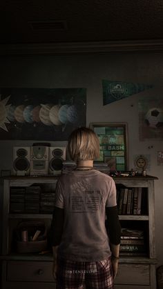 a young boy standing in front of a book shelf