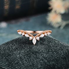 a rose gold ring with white stones on it