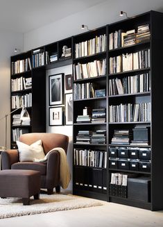 a living room filled with lots of bookshelves next to a couch and chair