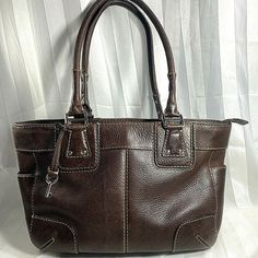 FOSSIL Brown Pebbled Leather Double Handled Zip Top Satchel Medium.  Dependable and cute workhorse casual style bag - roomy, with a 4.5" depth, 12" width & 9.5" height. Leather has been treated to look aged but also has some mild natural wear to it - some around the handle connectors.  This would be a very easy fix with edge coating, but could be left alone to contribute to the natural aged appearance. Exterior features 2 end side open pockets, silver tone hardware, studs and decorative stitchin Casual Textured Leather Satchel With Double Handle, Casual Textured Leather Double Handle Satchel, Casual Workwear Bags With Leather Lining, Casual Textured Leather Bags For Work, Casual Textured Leather Work Bag, Casual Leather Shoulder Bag With Silver-tone Hardware, Brown Bags With Silver-tone Hardware For Fall, Casual Brown Satchel With Leather Lining, Brown Satchel With Silver-tone Hardware For Work