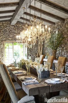 the dining room table is set with place settings for six people and has a chandelier hanging from the ceiling