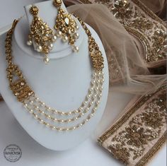 a white display with gold jewelry on it