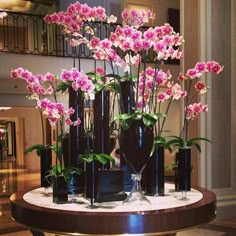 a table topped with vases filled with pink flowers