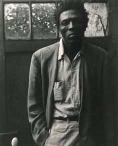 a man standing in front of a window next to a tennis ball