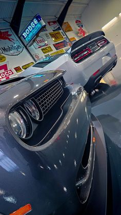 the front end of a gray sports car in a showroom