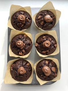 six chocolate muffins sitting on top of each other in cupcake liners