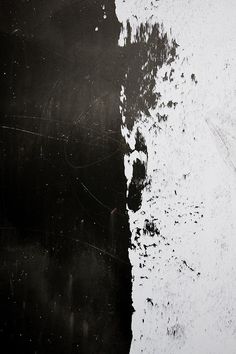 an abstract black and white painting with paint splattered on it's surface