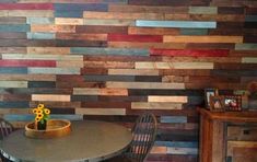 a dining room table with two chairs next to a wall made out of wooden planks