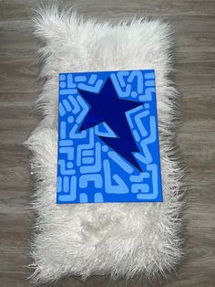 a blue and white rug with a star in the middle on top of wood flooring