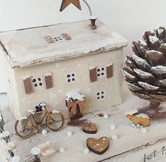 a small house with two bikes and a pine cone on the table next to it