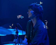 a man sitting in front of a drum set