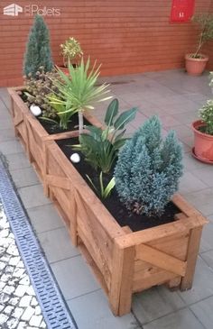 a wooden planter filled with lots of plants