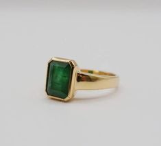 Green 14k Gold Signet Ring With Bezel Setting, Classic Jewelry With Emerald Cut Bezel Setting, Classic Emerald Signet Ring With Bezel Setting, Classic Emerald Ring With Smooth Bezel For Anniversary, Classic Emerald Cut Jewelry With Bezel Setting, Classic Emerald Cut Bezel Set Jewelry, Timeless Bezel-set Emerald Cut Emerald Ring, Classic Green Ring With Smooth Bezel, Fine Jewelry Emerald Cut Rings With Bezel Setting