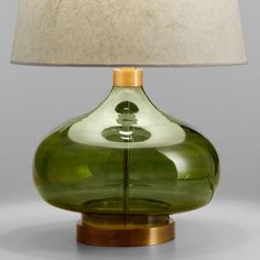 a green glass table lamp with a white shade