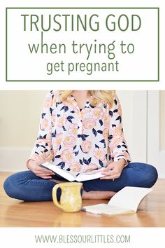 a woman sitting on the floor reading a book with text overlay that reads, trusting god when trying to get pregnant