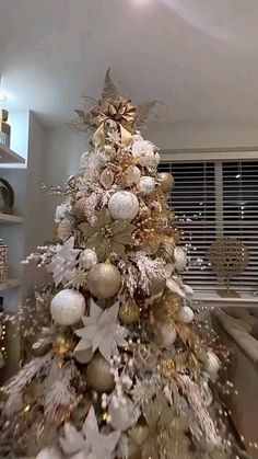 a white and gold christmas tree in a living room