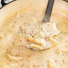 a ladle full of soup with dumplings and broccoli in the background