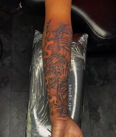 a person with a tattoo on their arm holding onto a piece of paper that is wrapped in foil