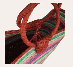 This hand-woven basket bag made of multicolored raffia can be carried by hand thanks to its round handles. It is possible to close the bag with raffia cords located in the middle. The handicraft respects a sustainable and environmentally friendly production with local communities by promoting the employment of women from disadvantaged backgrounds. Width flat: about 57 cm - Height flat: about 33 cm - Height with handles: about 55 cm Weight: about 1125 g Warning: to preserve your bag, please avoid Artisan Multicolor Bucket Straw Bag, Artisan Multicolor Straw Bucket Bag, Multicolor Jute Crochet Bag For Shopping, Multicolor Jute Straw Bag For Shopping, Multicolor Jute Beach Bag In Basket Shape, Multicolor Jute Basket Beach Bag, Multicolor Handwoven Beach Bag Made Of Natural Fiber, Multicolor Handwoven Natural Fiber Beach Bag, Bucket Straw Bag With Braided Handles In Multicolor