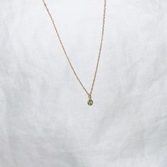 "BABY GREEN Sapphire necklace A mint green solitaire necklace featuring a Green Sapphire bezel charm in 18k gold set on a dainty 14k Yellow Gold double rope chain. The subtle green of this Sapphire stone is mesmerizing. Necklace length is 16\" and sits under your clavicle and is the perfect length for layering with other necklaces. A perfect minimalist statement: chic and effortless. + Green Sapphire stone 2.5mm + 18k Gold bezel finish + Green Sapphire Weight - 0.14 Carats, Gold Weight - 0.082 G Green Sapphire Necklace, Green Gemstone Necklace, Pastel Jewelry, Green Stone Necklace, Meaningful Necklace, Baby Green, Green Pendant, Wedding Bridesmaid Jewelry, Solitaire Necklace