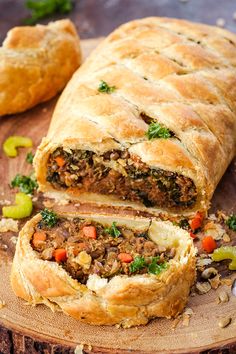 a meat filled pastry cut in half on a cutting board