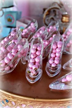 pink candies in clear plastic containers sitting on a table next to other candy items