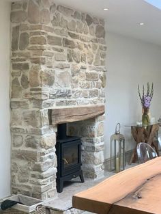 a living room with a stone fireplace and wooden table