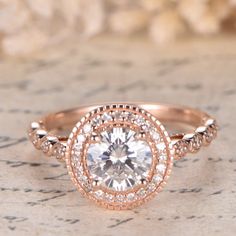 a rose gold engagement ring with an oval center surrounded by round diamonds