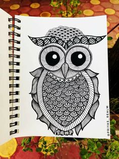 an owl is drawn in black and white on a notebook