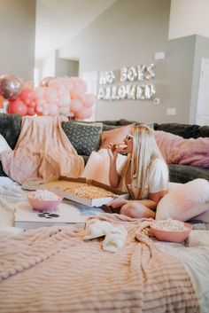 a woman is sitting on the couch eating popcorn