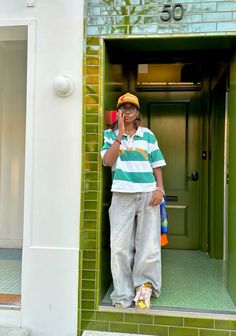 a man standing in the doorway of a building talking on his cell phone