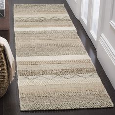 a beige and white rug on the floor next to a chair