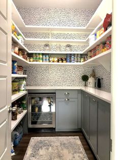 a kitchen with gray cabinets and white walls, an area rug on the wooden floor