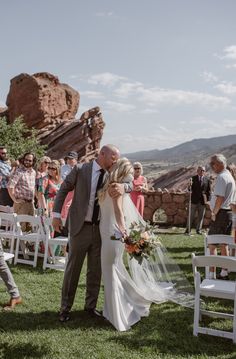 a bride and groom walking down the aisle after their wedding ceremony at red rock canyon