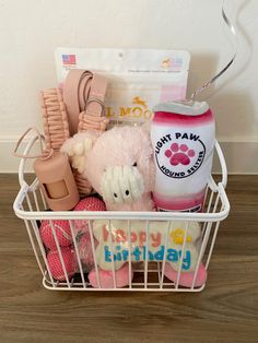 a white basket filled with lots of toys and items on top of a wooden floor