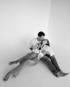 a man and woman laying on the floor kissing