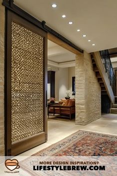 an open door leading to a living room with stairs and rugs on the floor