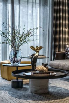 a living room filled with furniture and a vase on top of a table in front of a window