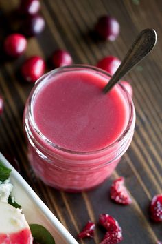 a small jar filled with fruit next to a spoon