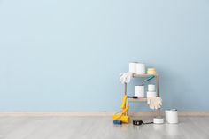 a room with blue walls and white paint rollers on the floor next to it