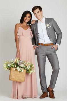 a man and woman in formal wear standing next to each other, posing for the camera