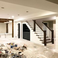 an unfinished room with stairs and paint all over the floor