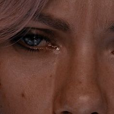 a close up of a woman's face with tears on her eyes and nose