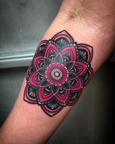 a close up of a person's arm with a flower tattoo on the wrist