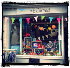 a store front with many items in the window and decorations hanging from it's windows